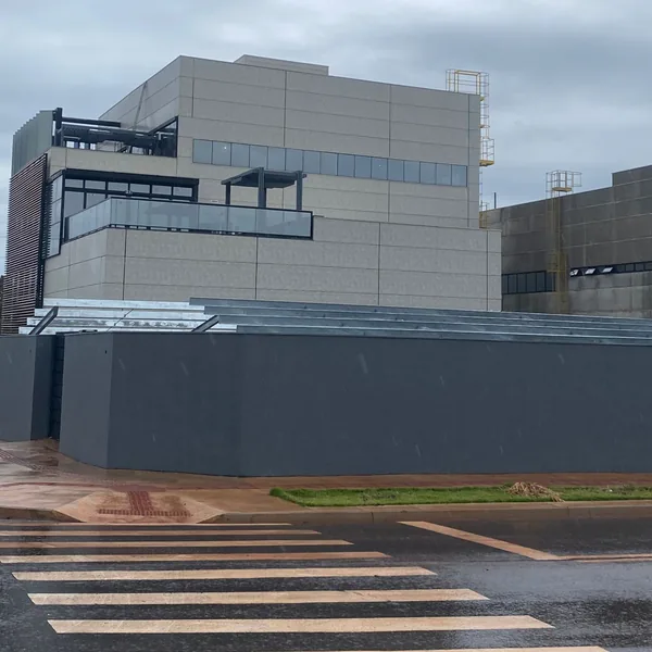 Fechamento metálico de fachada industrial com painéis e vedação em obra no Paraná
